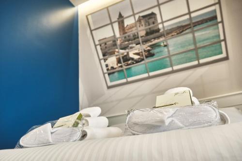 a room with a bed with towels and a picture on the wall at Michè luxury home - Appartamento vista mare a Trani in Trani