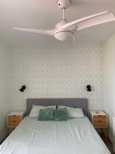 um quarto com uma cama branca e uma ventoinha de tecto em Precioso apartamento equipado en primera línea em Múrcia