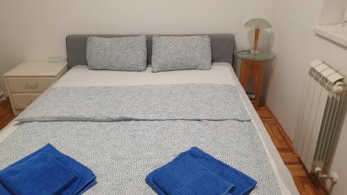 un letto con cuscini blu sopra di Apartman MM012 a Požarevac
