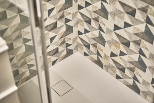 a bathroom with geometric tiles on the wall at Michè luxury home - Appartamento vista mare a Trani in Trani
