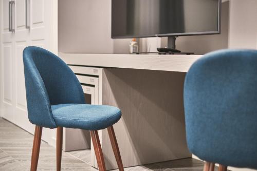 two blue chairs sitting in front of a desk at Michè luxury home - Appartamento vista mare a Trani in Trani