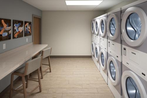 a laundry room with a row of washers and dryers at Candlewood Suites - Detroit - Auburn Hills by IHG in Auburn Hills
