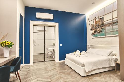 a blue bedroom with a bed and a blue wall at Michè luxury home - Appartamento vista mare a Trani in Trani