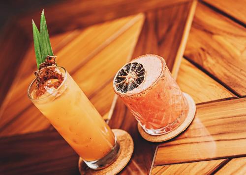 two cocktails sitting on a wooden table at Bahia del Sol Beach front Boutique Hotel in Potrero