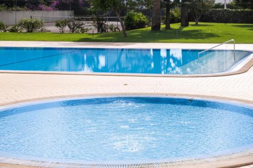 a large pool with blue water in a yard at Apartment Santorini by Algarve Vacation in Alvor