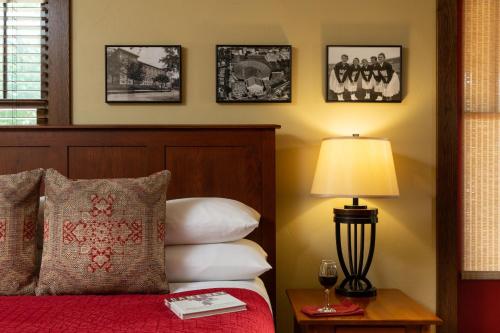 a bedroom with a bed and a lamp and pictures on the wall at The Buckingham Inn in Madison