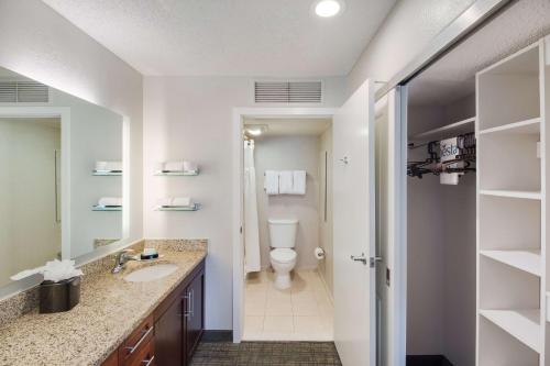 a bathroom with a toilet and a sink at Sonesta ES Suites Huntington Beach Fountain Valley in Huntington Beach