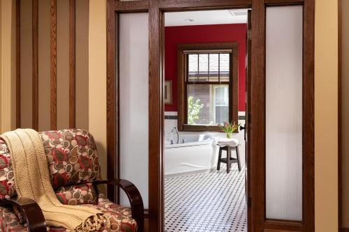 uma casa de banho com uma banheira, uma cadeira e uma banheira. em The Buckingham Inn em Madison