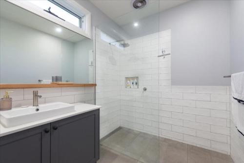 a white bathroom with a sink and a shower at Classic Contemporary Beach Beauty in Inverloch