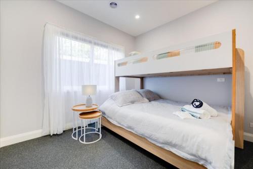 a bedroom with a bunk bed and a table at Classic Contemporary Beach Beauty in Inverloch