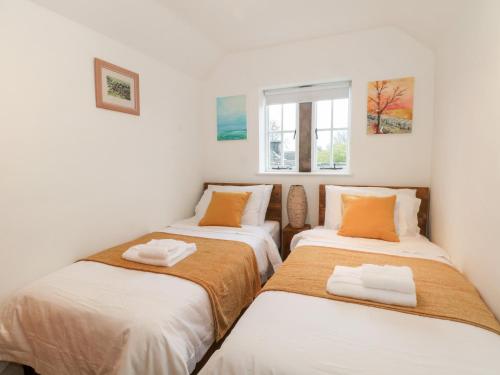 two twin beds in a room with a window at Dragon Cottage in Bakewell