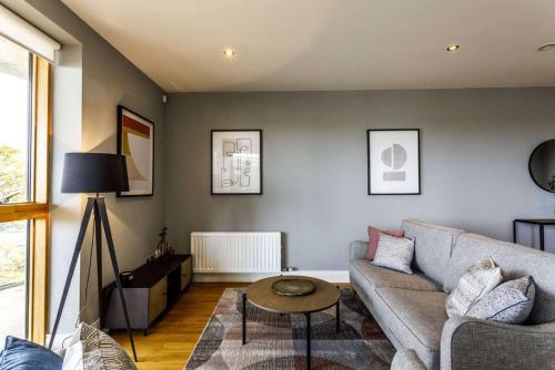 uma sala de estar com um sofá e uma mesa em Private Room Available in Spacious High Rise Apartment with Park & City View em Dublin