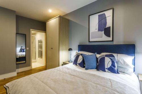 a bedroom with a large bed with blue and white pillows at Private Room Available in Spacious High Rise Apartment with Park & City View in Dublin