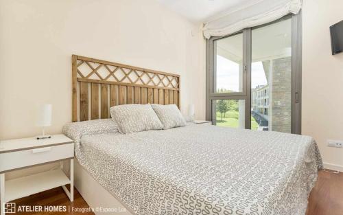 Un dormitorio con una cama grande y una ventana en Duplex Las Margas Vista Montañas, en Sabiñánigo