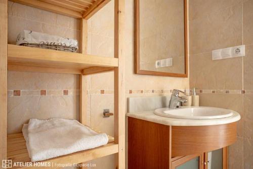 y baño con lavabo y espejo. en Duplex Las Margas Vista Montañas, en Sabiñánigo