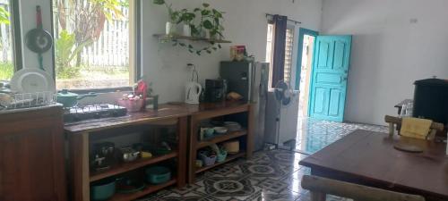 a kitchen with a refrigerator and a table and a door at Bikini Beach in El Remate