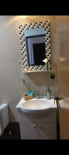 y baño con lavabo blanco y espejo. en Sweet apart Nueva Córdoba en Córdoba