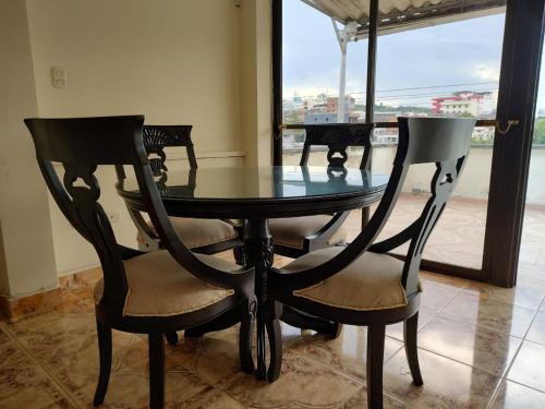a glass table and two chairs in a room with a window at Apto Terraza Resort SRC in Santa Rosa de Cabal