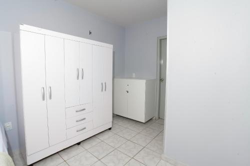 a white closet with white cabinets in a room at Apartamento confortável in Goiânia