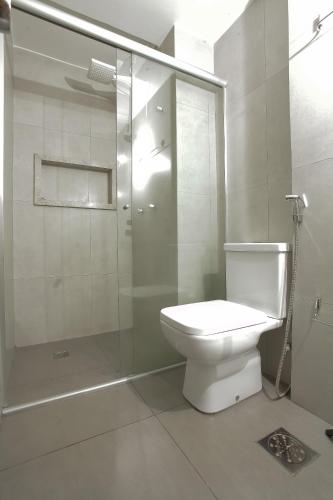 a bathroom with a toilet and a glass shower at Apartamento confortável in Goiânia
