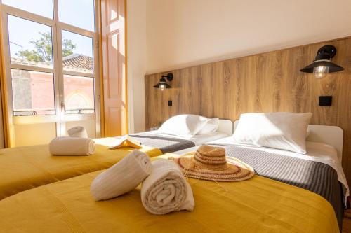 1 dormitorio con 2 camas, toallas y ventana en GrowIN Digital Nomads, en Faro