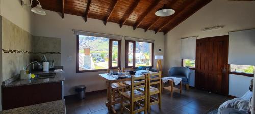uma cozinha e sala de jantar com mesa e cadeiras em Kuntur Apart em El Chaltén