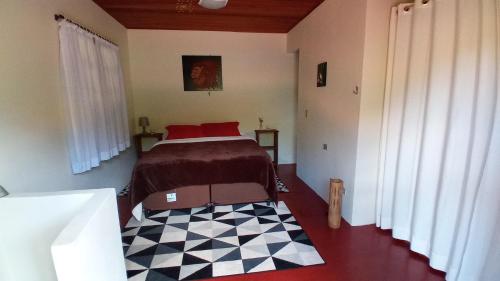 a bedroom with a bed and a checkered floor at Chale vista verde in São José dos Campos