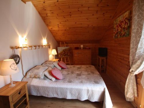 une chambre avec un lit dans une cabane en bois dans l'établissement Chalet chaleureux avec sauna, terrain, terrasse et babyfoot à Saint-Nabord - FR-1-589-255, à Saint-Nabord