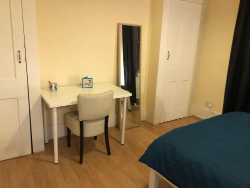 Zimmer mit einem Tisch, einem Stuhl und einem Bett in der Unterkunft Private room in Highgate London in London