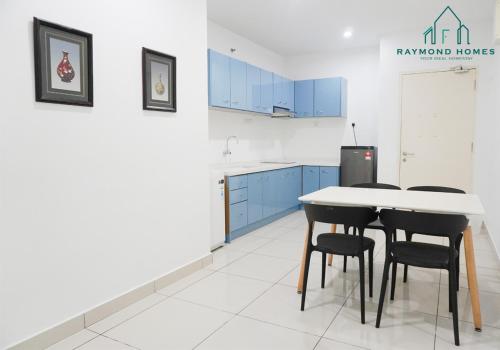 a kitchen with blue cabinets and a table and chairs at Gurney Drive Mansion One Serviced Apartment in George Town