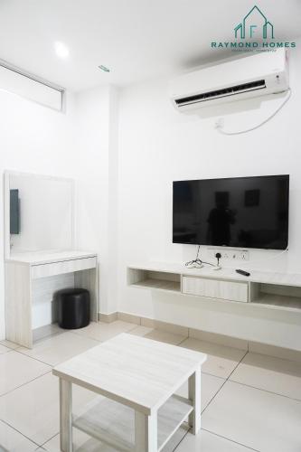 a white living room with a table and a tv at Gurney Drive Mansion One Serviced Apartment in George Town