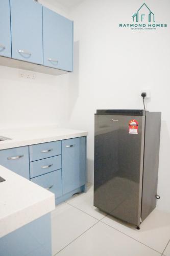 a kitchen with blue cabinets and a refrigerator at Gurney Drive Mansion One Serviced Apartment in George Town