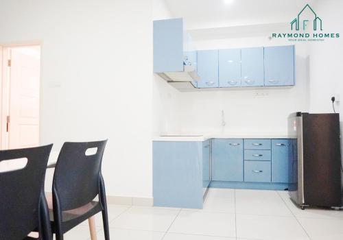 a kitchen with blue cabinets and a table and chairs at Gurney Drive Mansion One Serviced Apartment in George Town