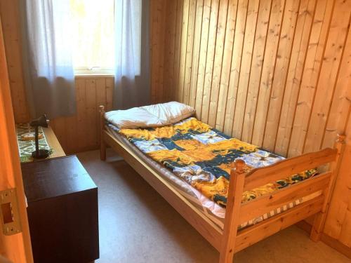 Cama en habitación con pared de madera en Holiday home NORDMALING en Nordmaling