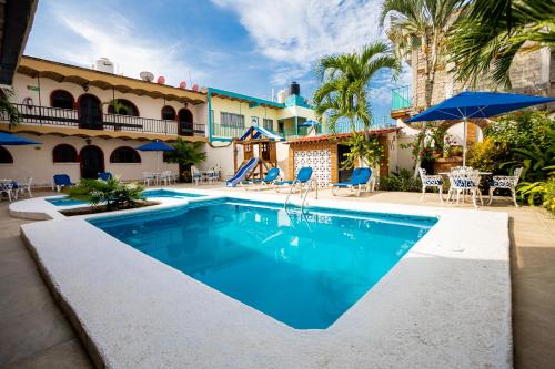 a swimming pool in front of a house at Bungalows Maria Teresa in Rincon de Guayabitos