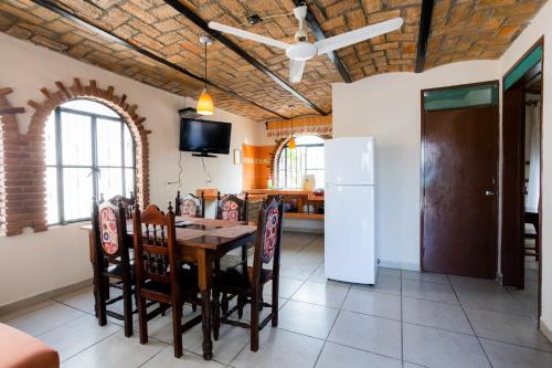 a kitchen and dining room with a table and chairs at Bungalows Maria Teresa in Rincon de Guayabitos