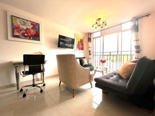 a living room with a couch and a chair and a desk at HERMOSO APTO CON VISTA a LAS MONTAÑAS DEL QUINDÍO CERCA de TODO in Armenia