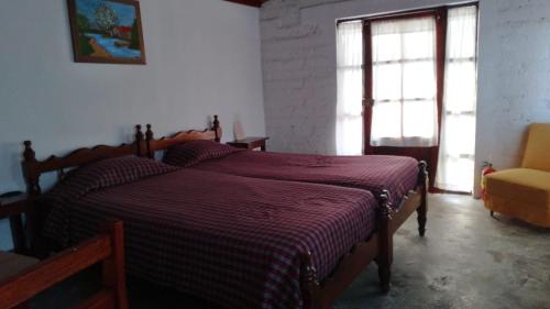 1 dormitorio con 2 camas y ventana en Hotel Las Aldas, en Casma