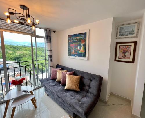 a living room with a couch and a table at HERMOSO APTO CON VISTA a LAS MONTAÑAS DEL QUINDÍO CERCA de TODO in Armenia