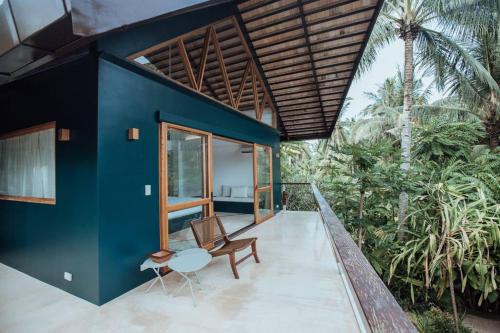 a blue house with a chair and a table at Maison Bukana - King Suite in General Luna