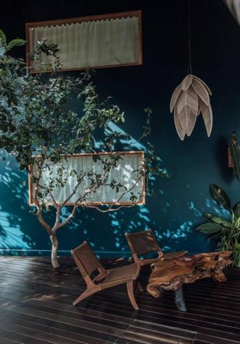 a room with a blue wall with a tree and a chair at Maison Bukana - King Suite in General Luna