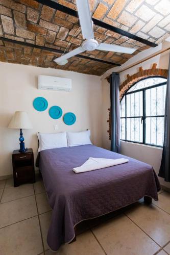 a bedroom with a bed with blue plates on the wall at Bungalows Maria Teresa in Rincon de Guayabitos