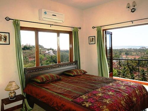 a bedroom with a bed and a large window at Dona Paula Apartment in Dona Paula