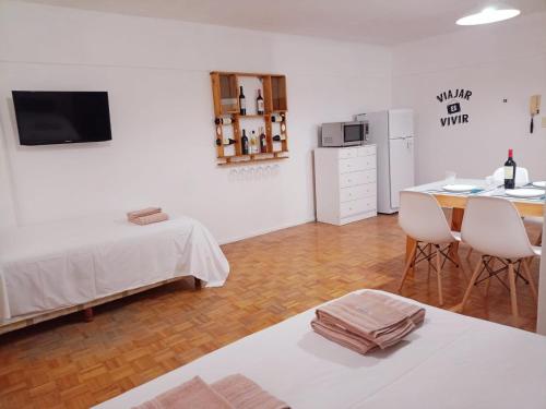 Habitación con mesa y cocina con nevera. en Mendoza Apartment en Mendoza