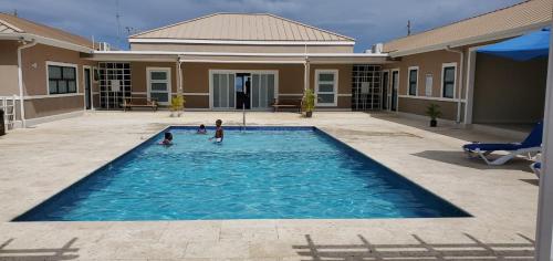dwójka dzieci bawiących się w basenie w domu w obiekcie Jamaica Tranquility w mieście Lucea