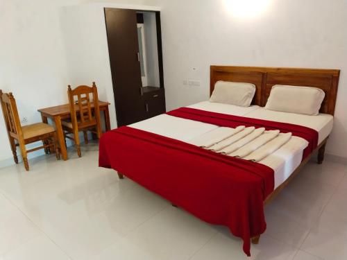 a bedroom with a large bed with a red blanket at Hotel Neptune Kovalam in Trivandrum