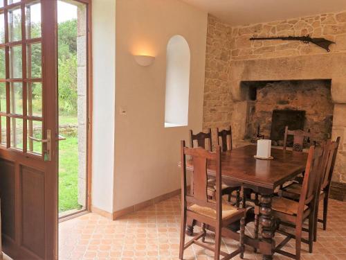 une salle à manger avec une table et une cheminée en pierre dans l'établissement Apartment in Bénodet near Sandy Beaches, à Bénodet