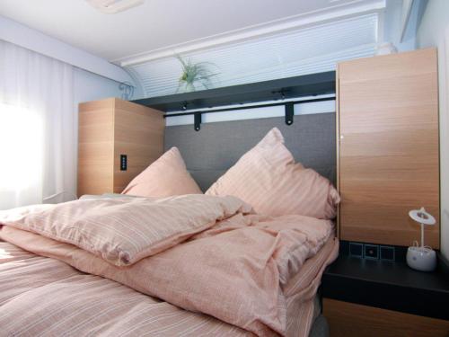 a bedroom with a large bed with pink pillows at Dreamer Luxus-Caravan am Achterwasser, Lütow in Lütow