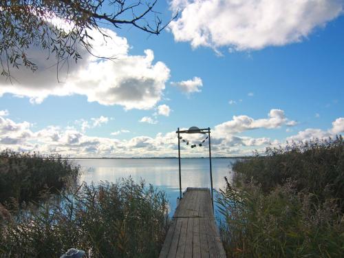 a wooden dock with a light on the water at Dreamer Luxus-Caravan am Achterwasser, Lütow in Lütow