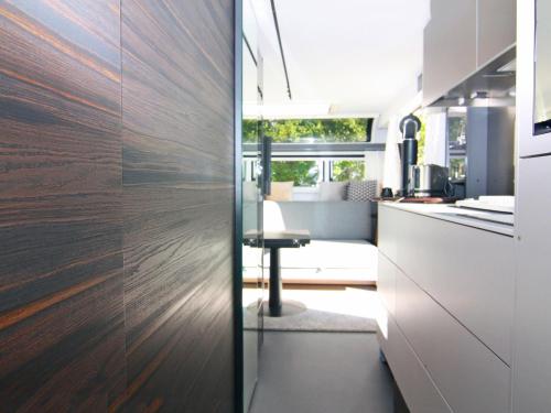 a kitchen with white cabinets and wood paneling at Dreamer Luxus-Caravan am Achterwasser, Lütow in Lütow